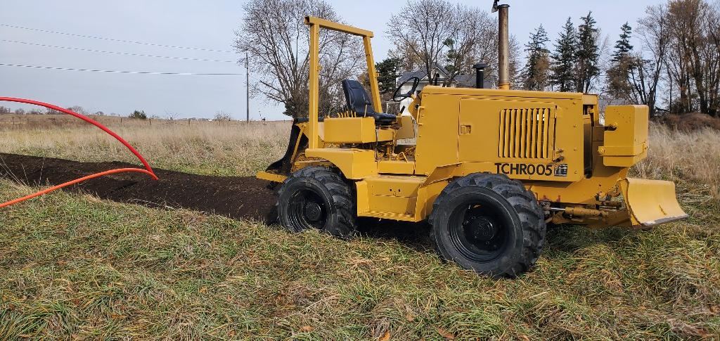 Yellow trencher and loader working on an Iowa job site